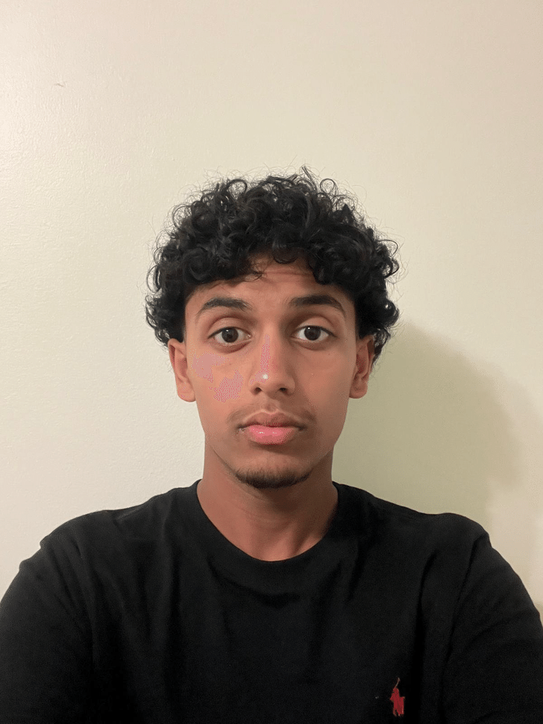 Portrait of Amaan Hussaini against a neutral background.