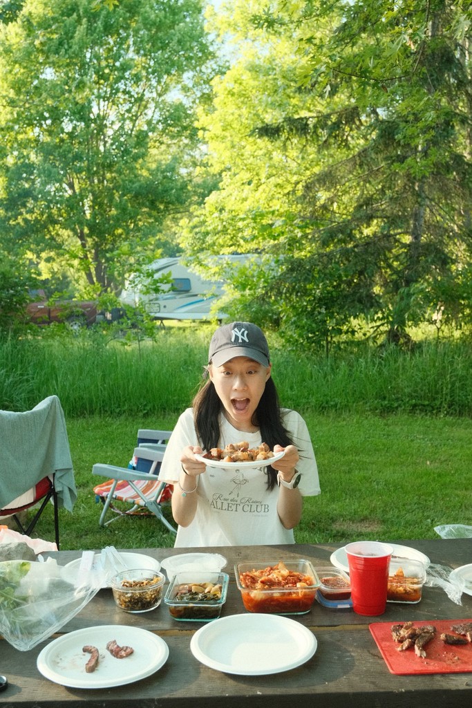 Christine Ha enjoying food outdoors, reflecting her interest in travel and food cultures.