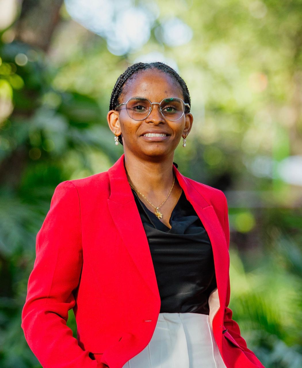 Jackline Ngowi standing outdoors in a red blazer.