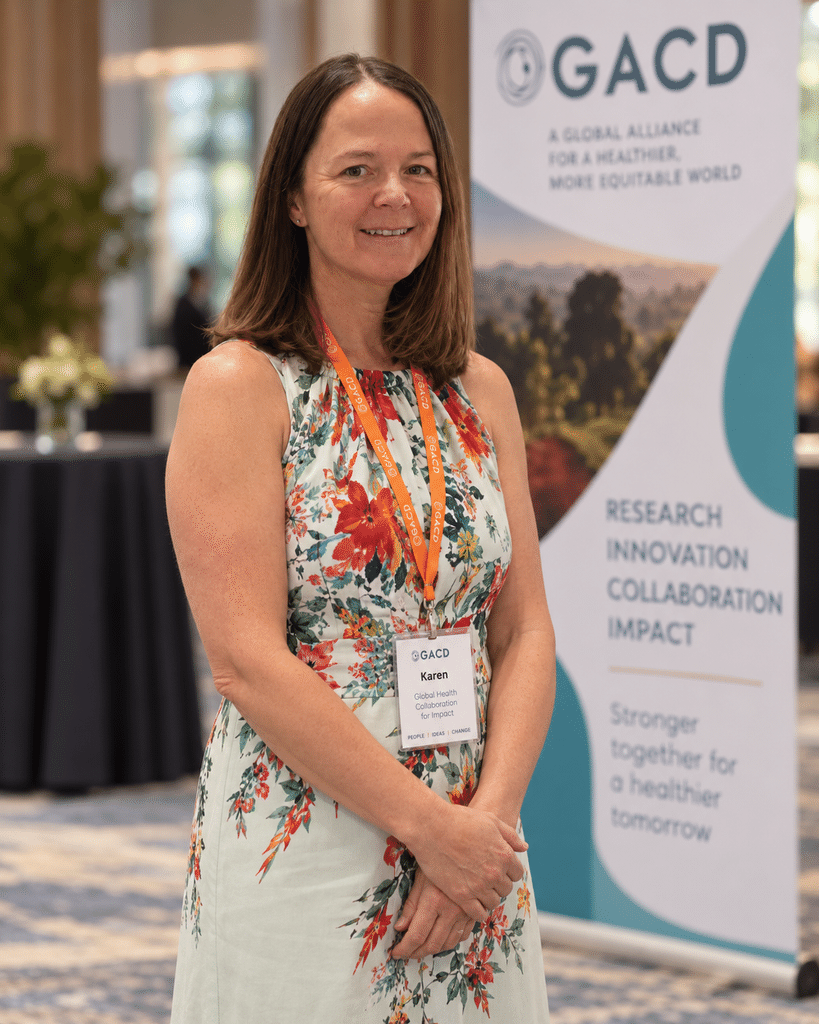 Karen Yeates at a GACD conference in a floral top.